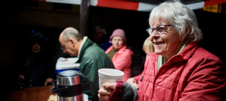 Elderly people having a hot drink.