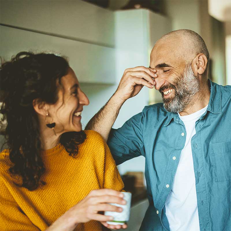 Man with beard, and woman with dark hair smiling and laughing