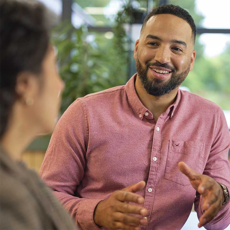 Smiling man talking to a woman