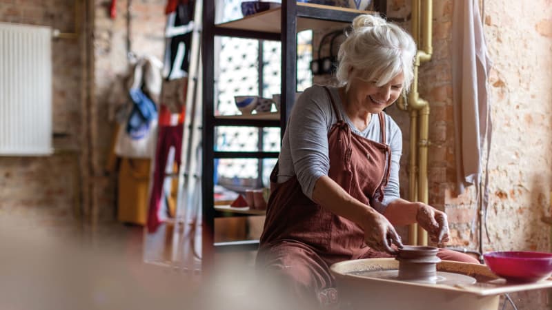 Woman sat at pottery wheel