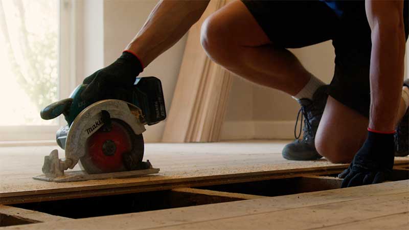 Man cutting floorboards with a circular saw