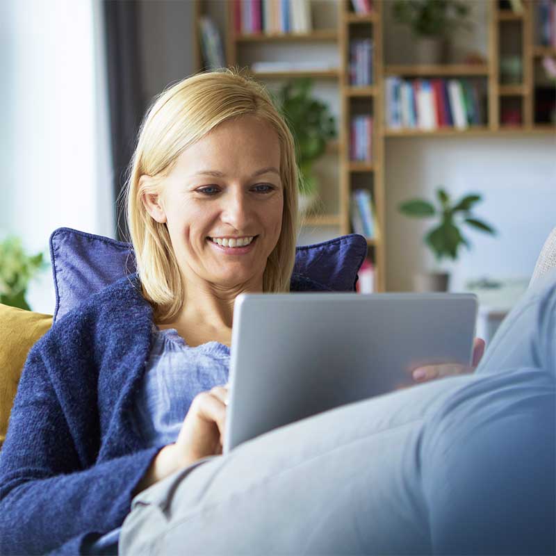 woman sat on sofa using tablet