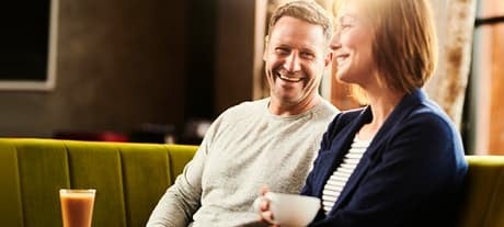 man and women drinking coffee in cafe