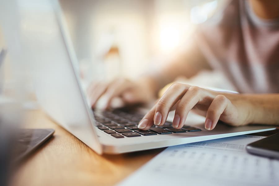 Female hands typing on a laptop