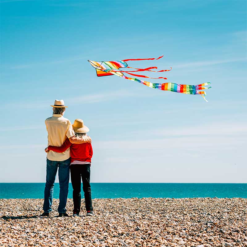 Couple on a beach flying a kite