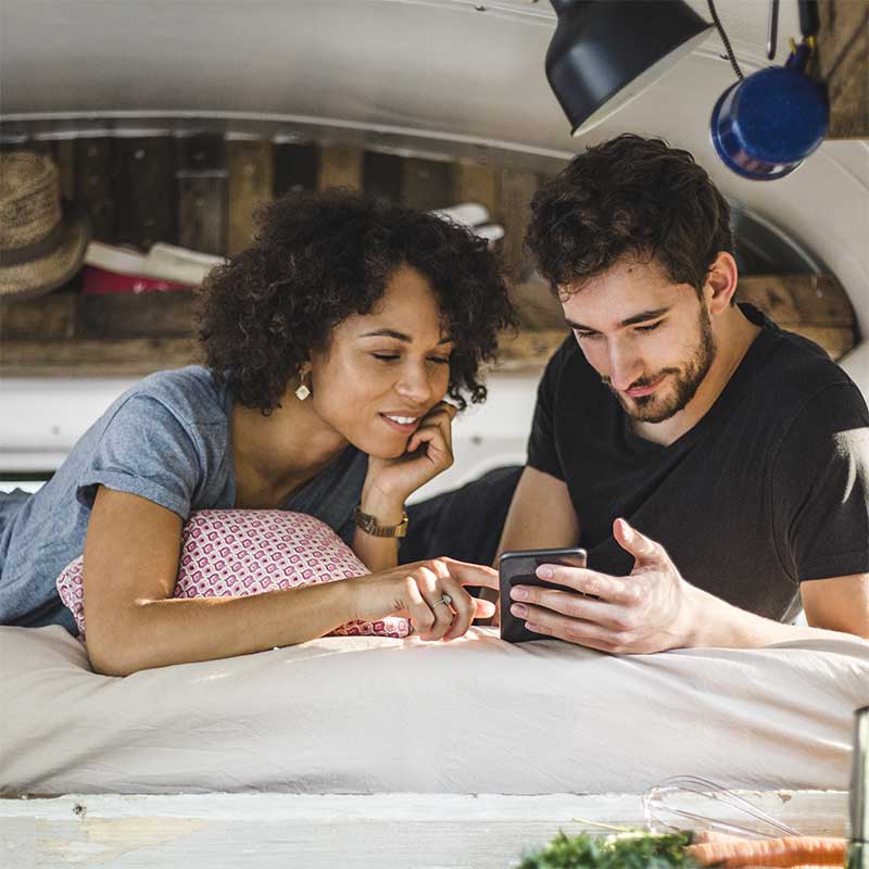 Couple looking at a phone in bed