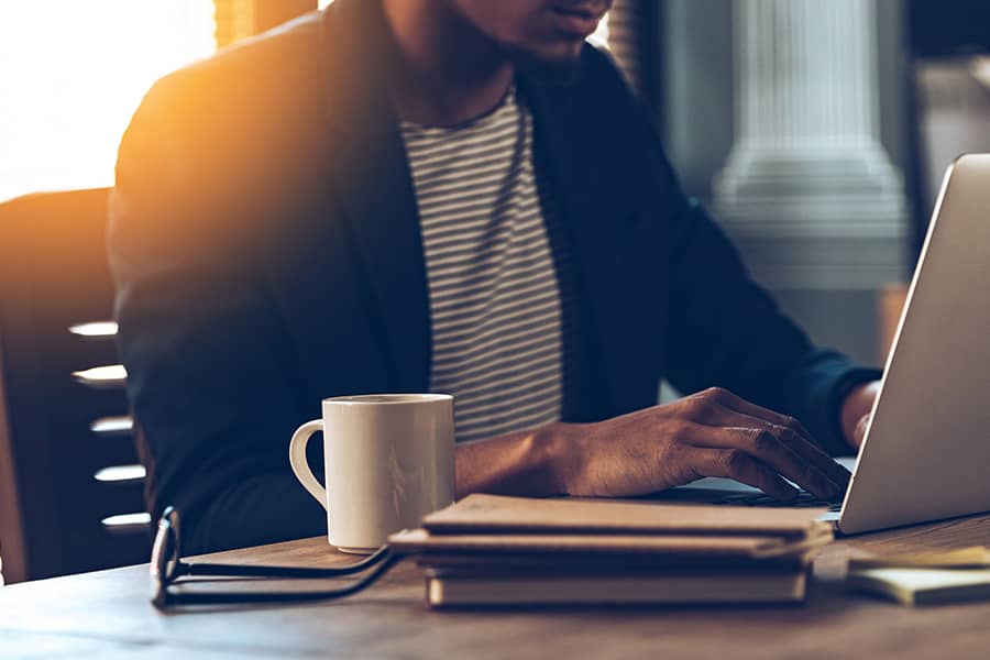 Man working on laptop with coffee 