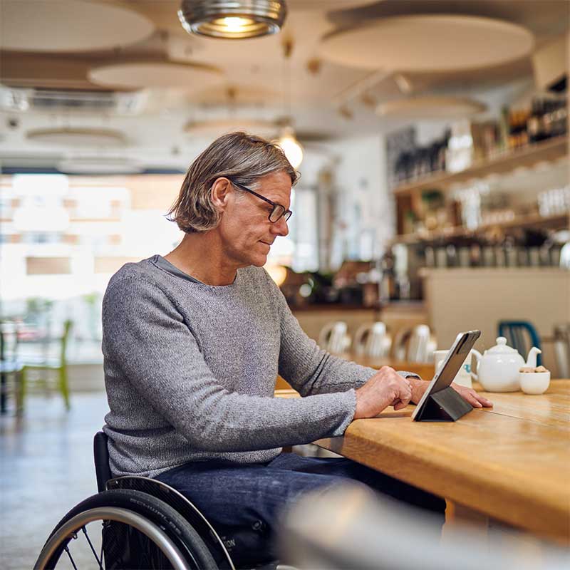 Man in wheelchair looking at tablet 