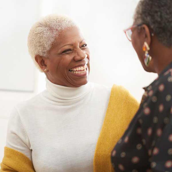 two retired women smiling and chatting