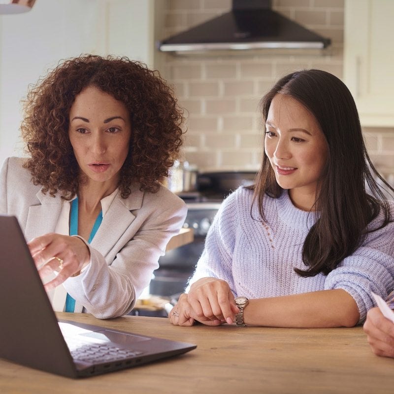 Young woman and Skipton Building Society employee looking at laptop