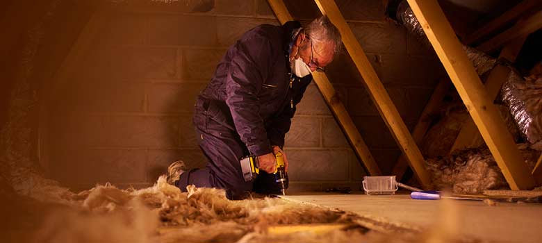 Man working in loft space wearing a dust mask