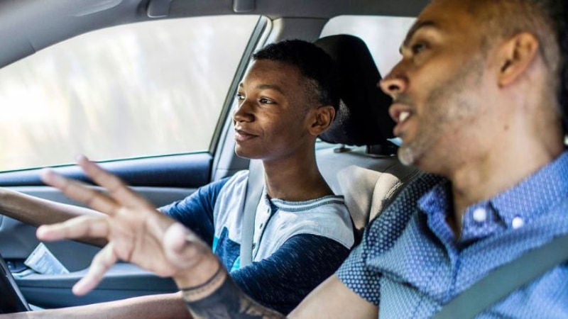 Two men one older one younger sat in a car