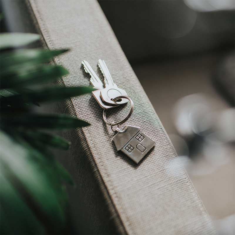 Two keys with a house shaped metal keychain