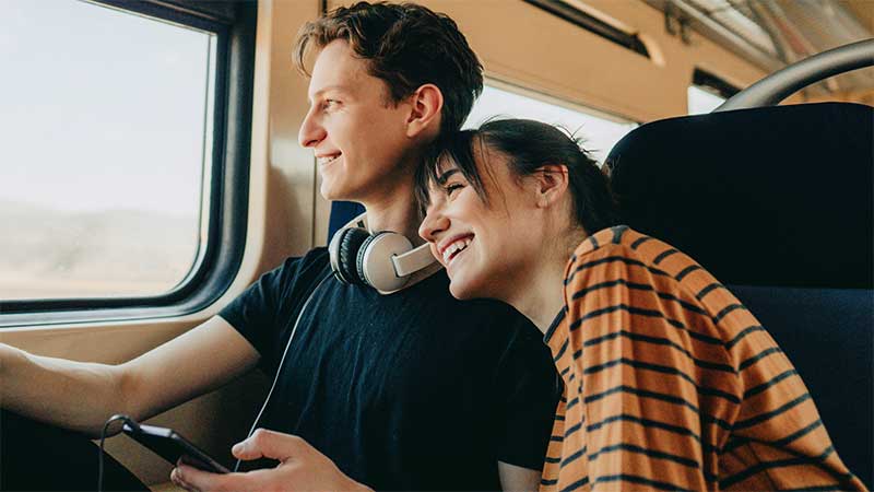 Couple smiling and looking out of train window