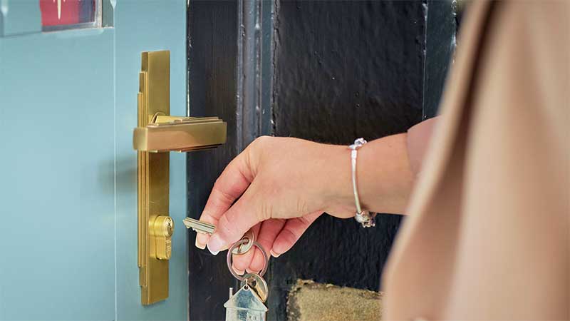 Woman's hand putting a key in a doorlock