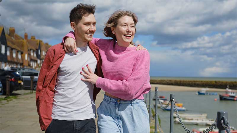 Smiling couple walking on seafront