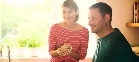 Man and woman with cup in a kitchen