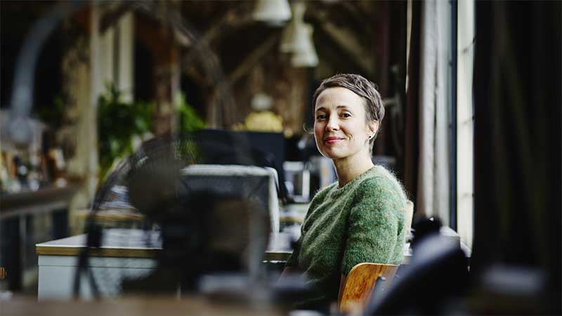 A woman sitting at a desk in a workshop